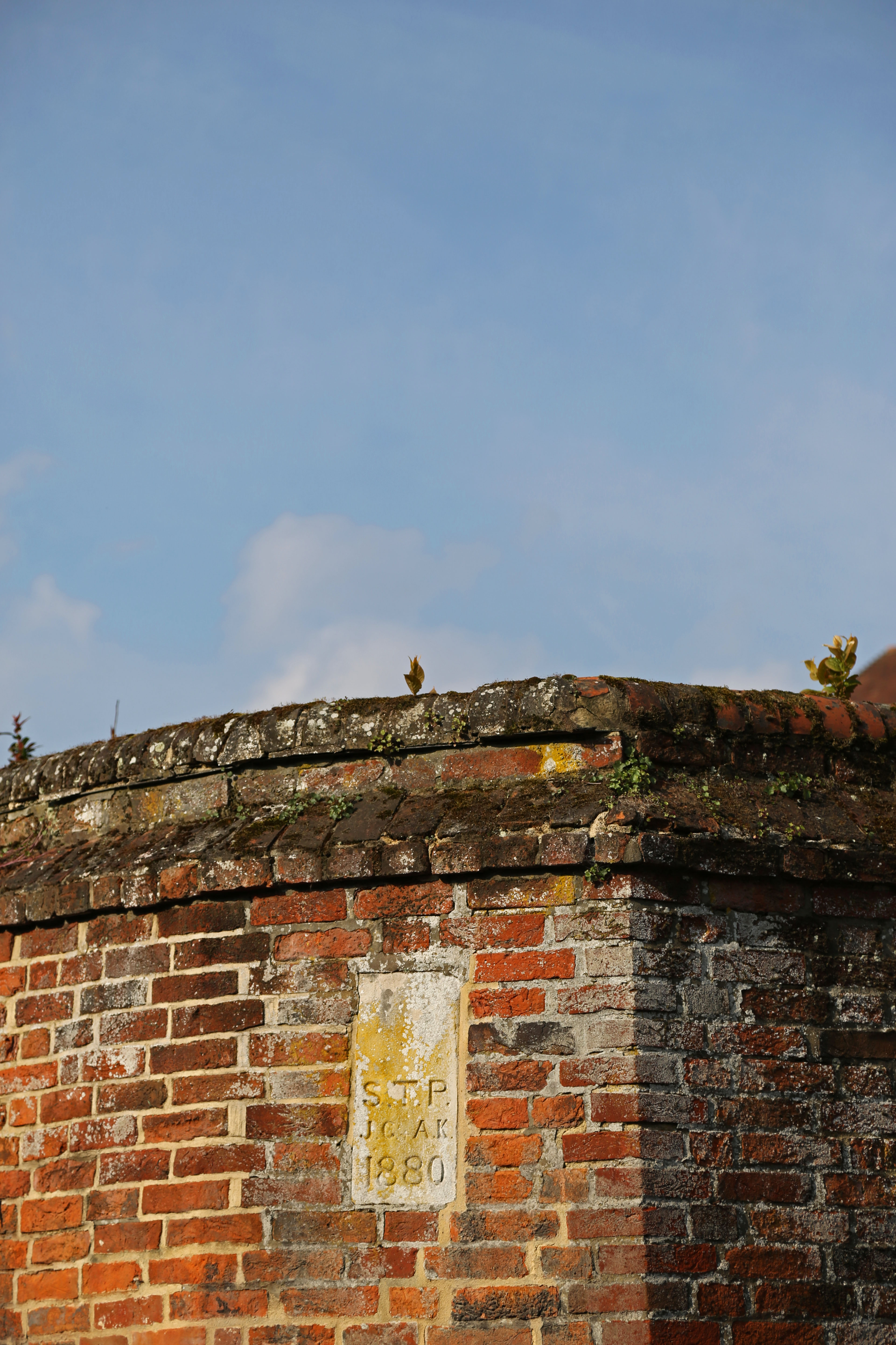 Corner of a wall, with eh year 1880 inscribed, against a blue sky