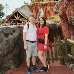Rosie and her partner Rory stood in front of Splash Mountain ride. Rosie is wearing a read tea dress from ASOS