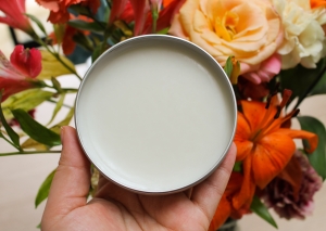 Open tin of Camomile Cleansing Butter against a bouquet of flowersmile Cleansing Butter against a bouquet of flowers