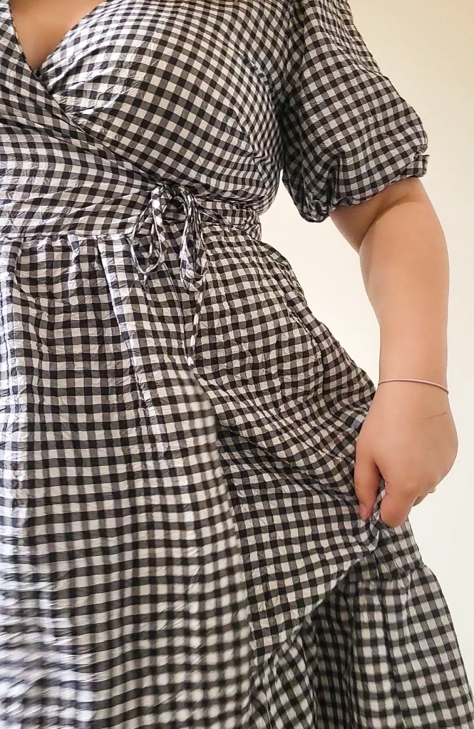 A close up of the dress - bust, to tie waist, to skirt. The dress is black and white checkered.