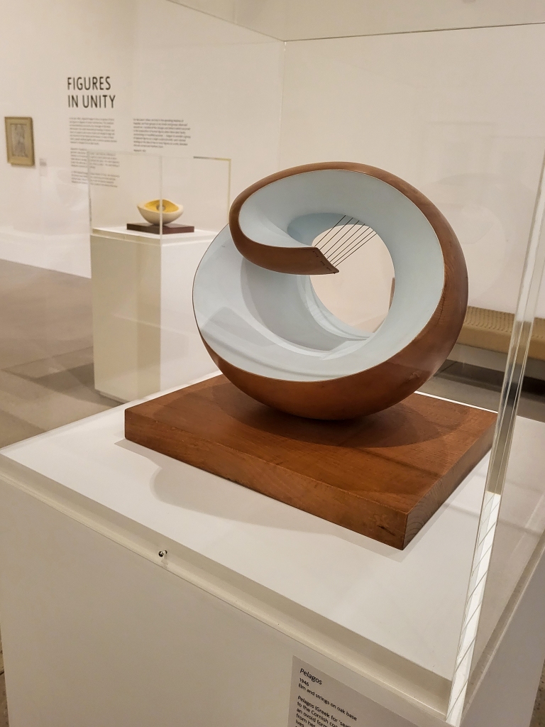 A pale blue and wooden rounded sculpture in a box